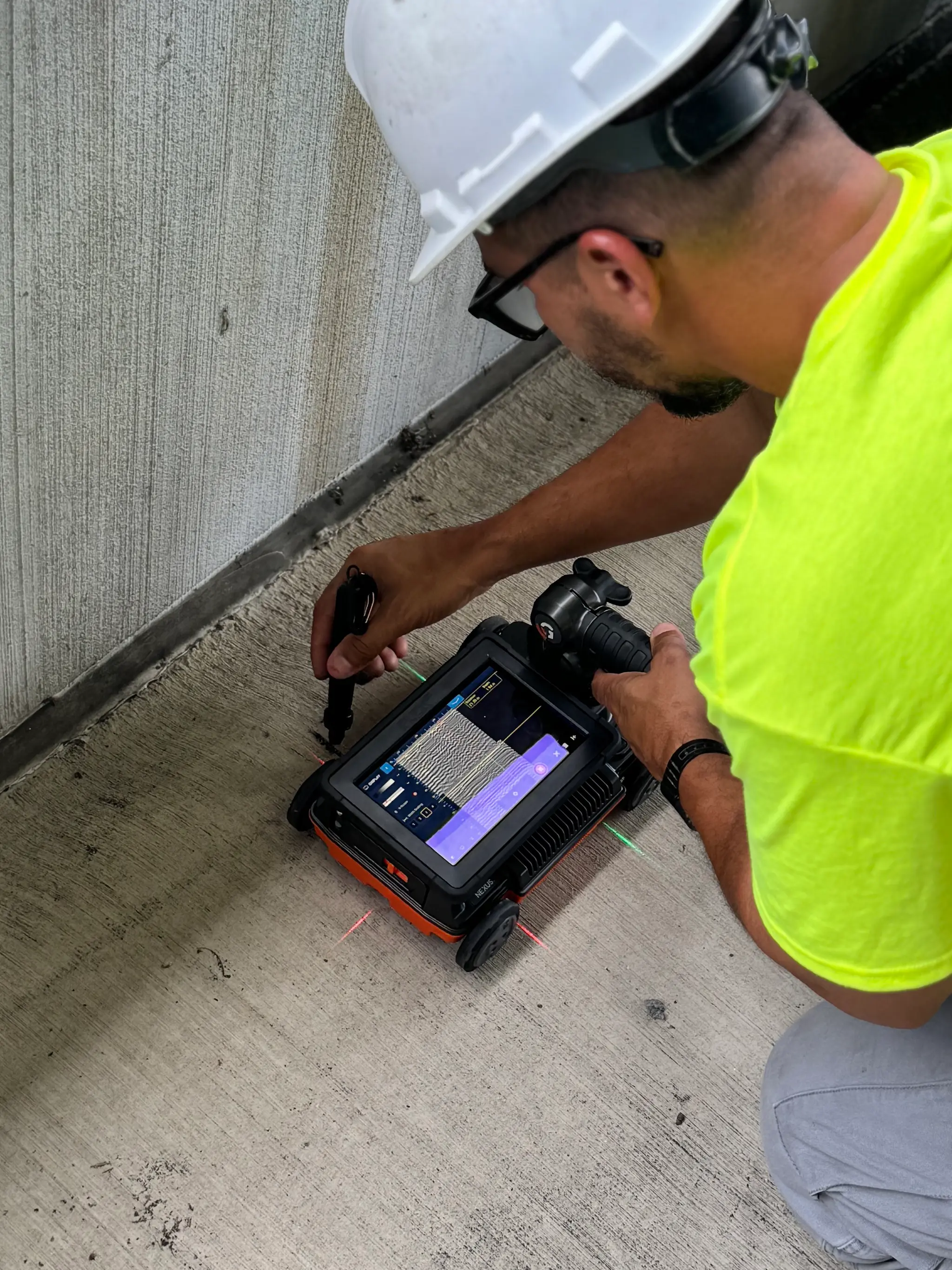 Technician performing GPR scanning on a job site
